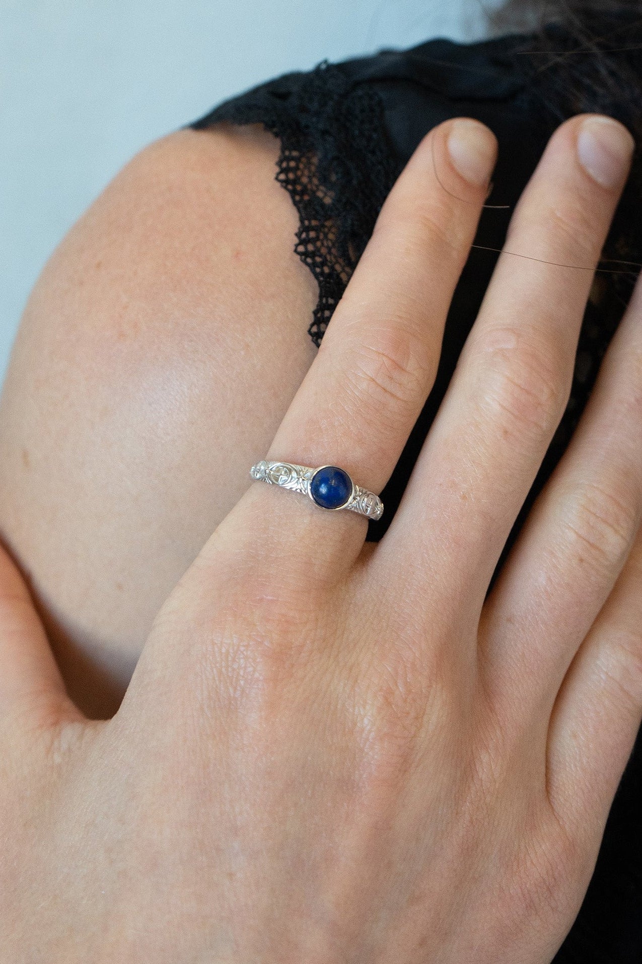 Silver celestial lapis lazuli ring with round blue center stone and engraved moon and star details