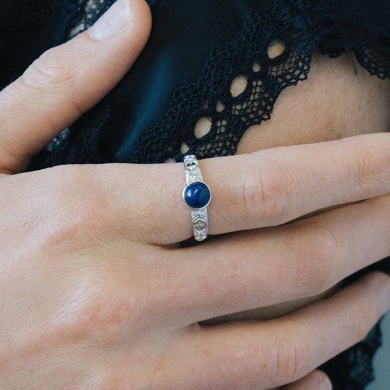 Silver celestial lapis lazuli ring with round blue center stone and engraved moon and star details