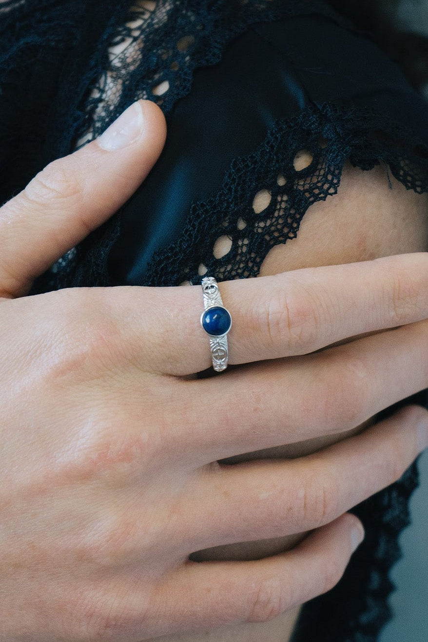 Silver celestial lapis lazuli ring with round blue center stone and engraved moon and star details