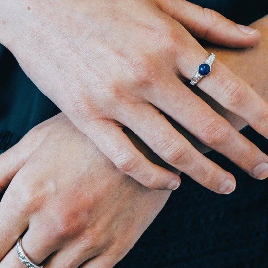 Silver celestial lapis lazuli ring with round blue center stone and engraved moon and star details