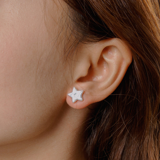 Dainty star pearl stud earrings worn on ear