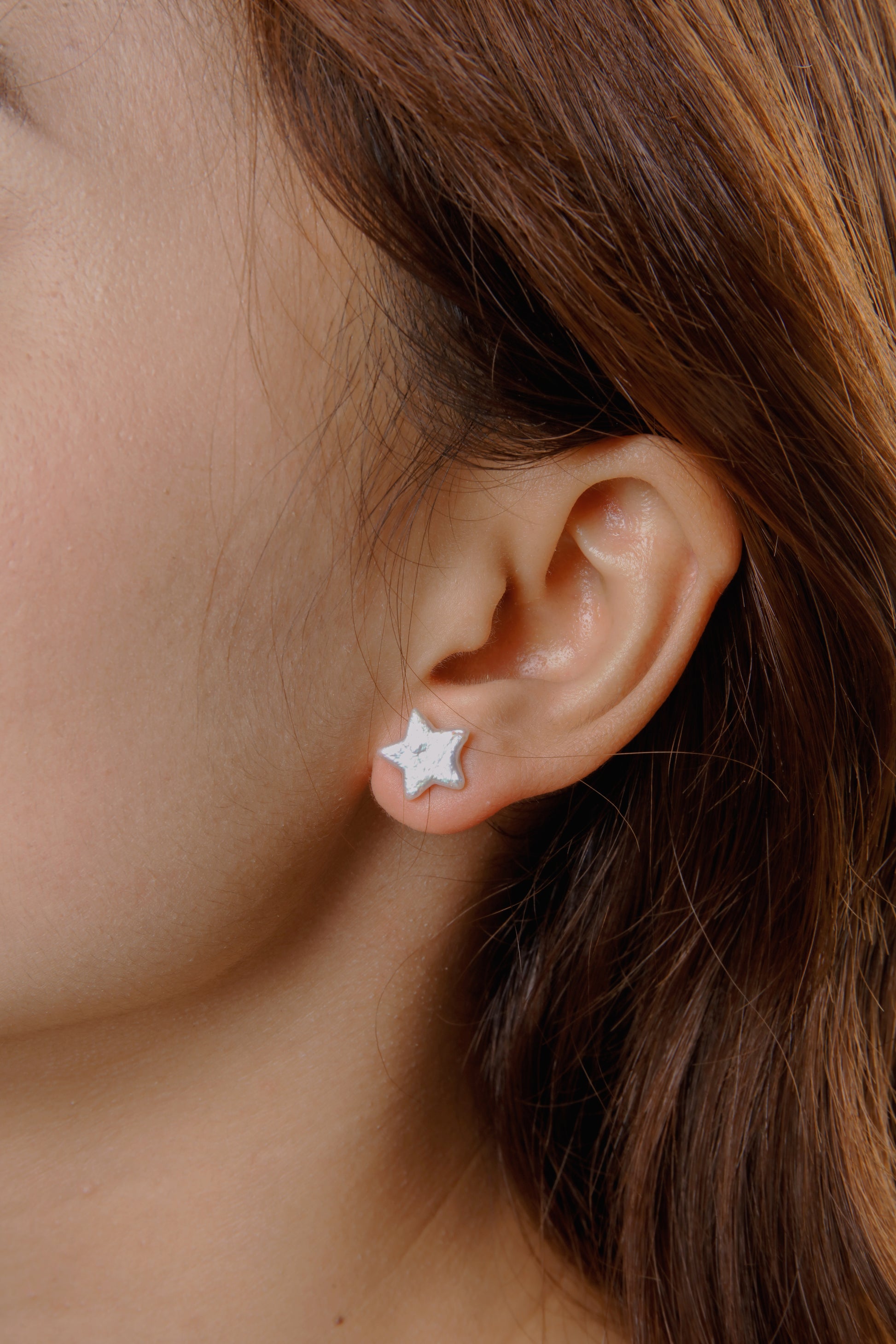 Dainty star pearl stud earrings worn on ear