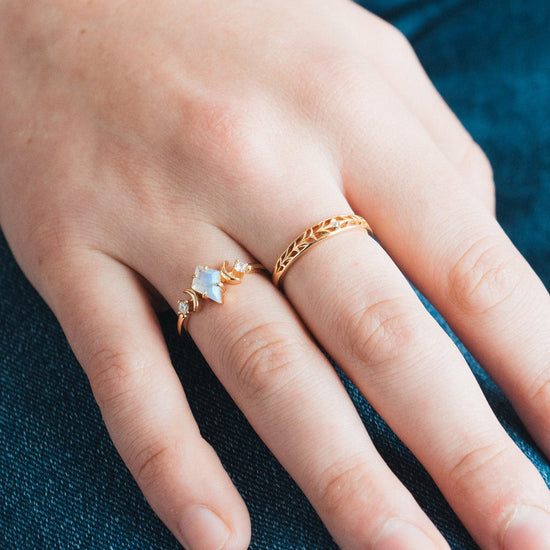 Intricately hollowed gold eternity band with a central starburst diamond, celestial stacking ring by LIRAE.