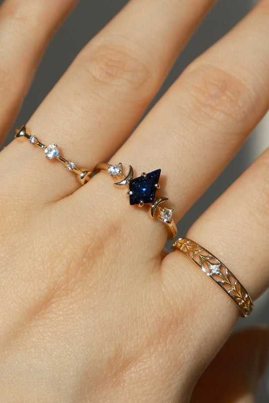 Intricately hollowed 14k gold eternity band with a central starburst diamond, celestial stacking ring by LIRAE.