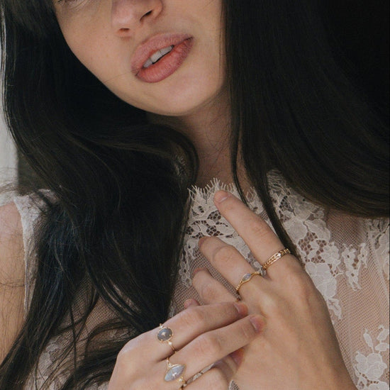 Intricately hollowed 14k gold eternity band with a central starburst diamond, celestial stacking ring by LIRAE.