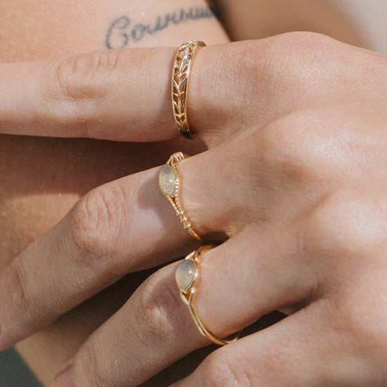 Intricately hollowed 14k gold eternity band with a central starburst diamond, celestial stacking ring by LIRAE.