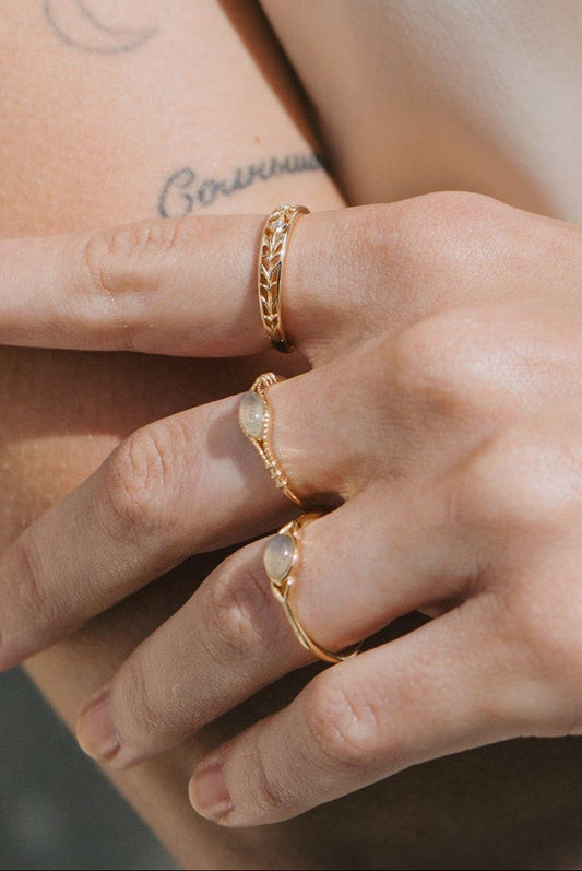 Intricately hollowed 14k gold eternity band with a central starburst diamond, celestial stacking ring by LIRAE.