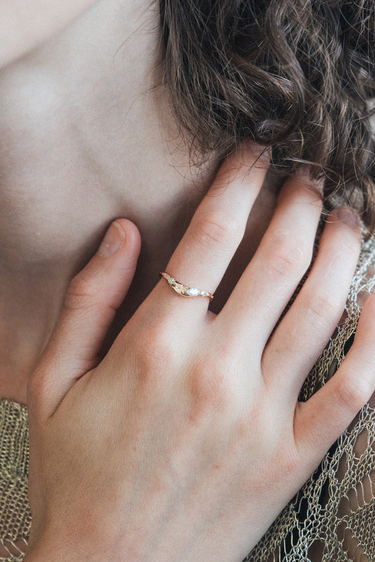 Gold curved celestial ring with marquise-cut Moissanite and engraved starburst details