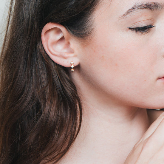Dainty gold starlight huggie hoop earrings with sparkling moissanite by LIRAE