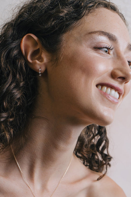 Dainty gold starlight huggie hoop earrings with sparkling moissanites by LIRAE