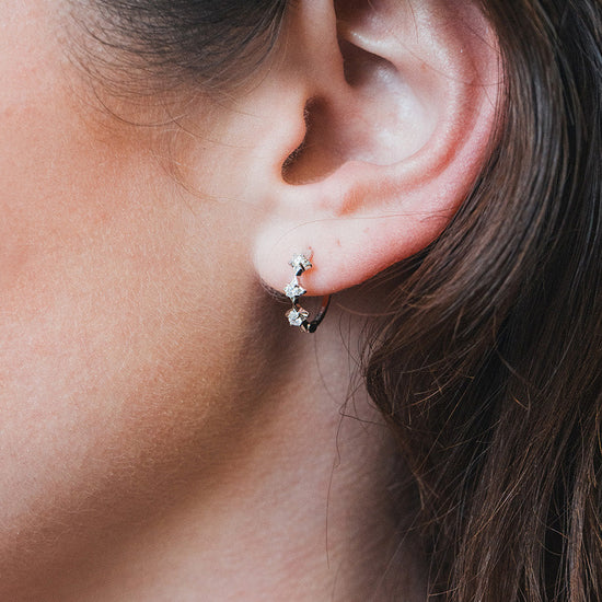 Dainty silver starlight huggie hoop earrings with sparkling moissanites by LIRAE