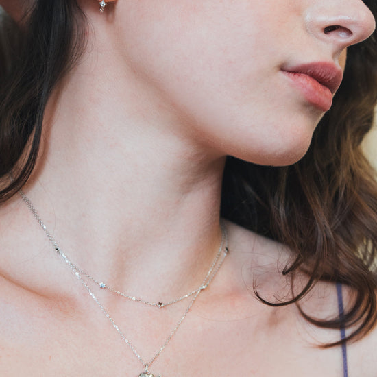 Dainty silver starlight huggie hoop earrings with sparkling moissanites by LIRAE