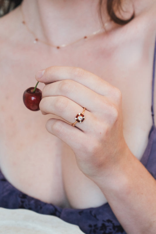 LIRAE vintage Art Deco ring with an octagon halo of red garnet baguettes and a white topaz center stone, geometric gold statement ring for women.