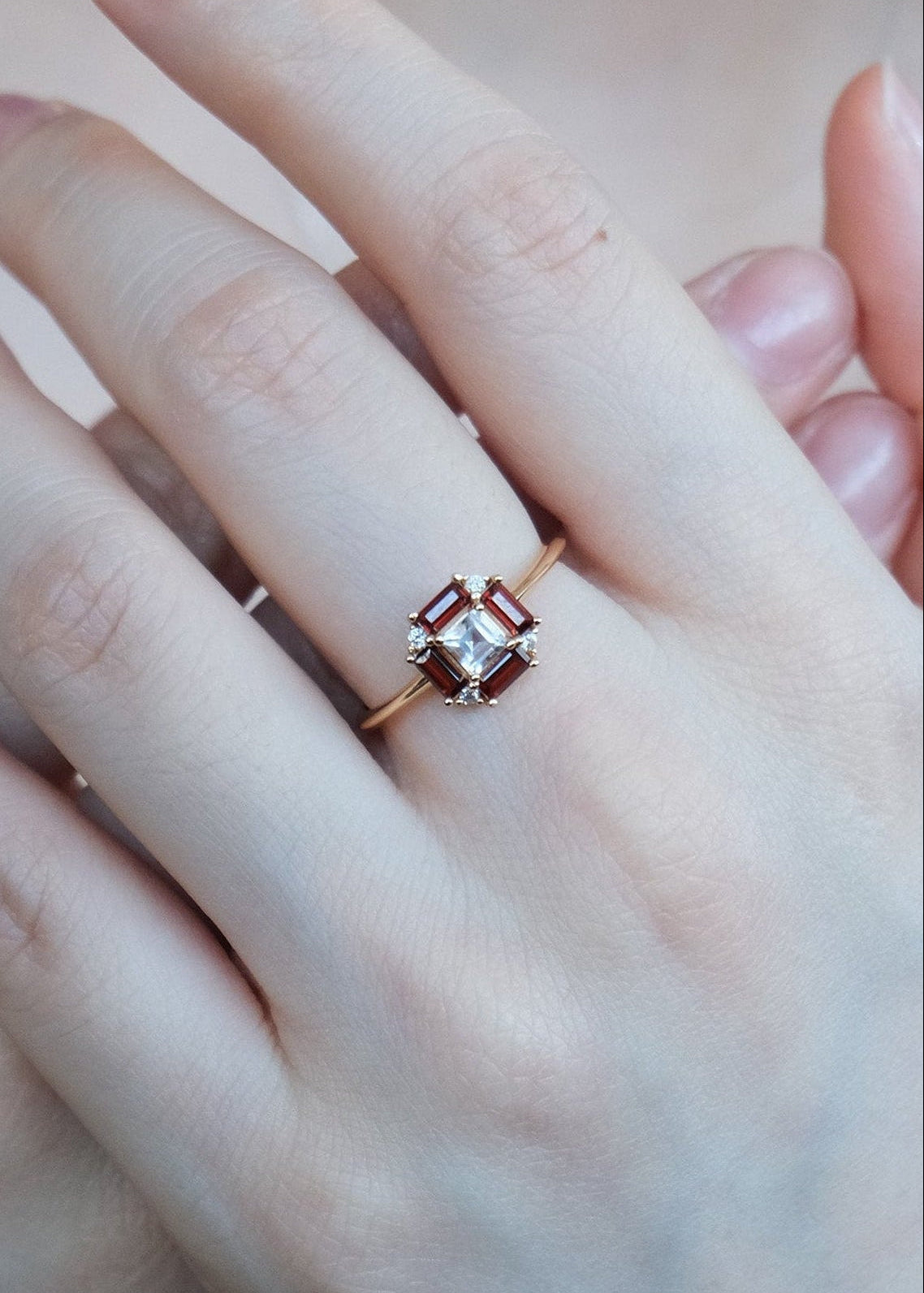 LIRAE vintage Art Deco ring with an octagon halo of red garnet baguettes and a white topaz center stone, geometric gold statement ring for women.