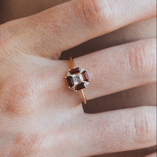 LIRAE vintage Art Deco ring with an octagon halo of red garnet baguettes and a white topaz center stone, geometric gold statement ring for women.