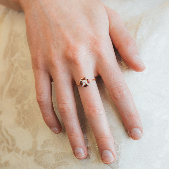 LIRAE vintage Art Deco ring with an octagon halo of red garnet baguettes and a white topaz center stone, geometric gold statement ring for women.