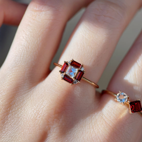 LIRAE vintage Art Deco ring with an octagon halo of red garnet baguettes and a white topaz center stone, geometric gold statement ring for women.