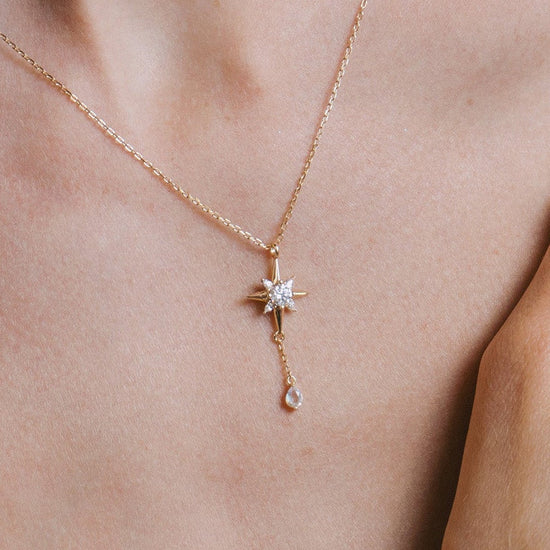 Gold north star necklace with a dangle moonstone.