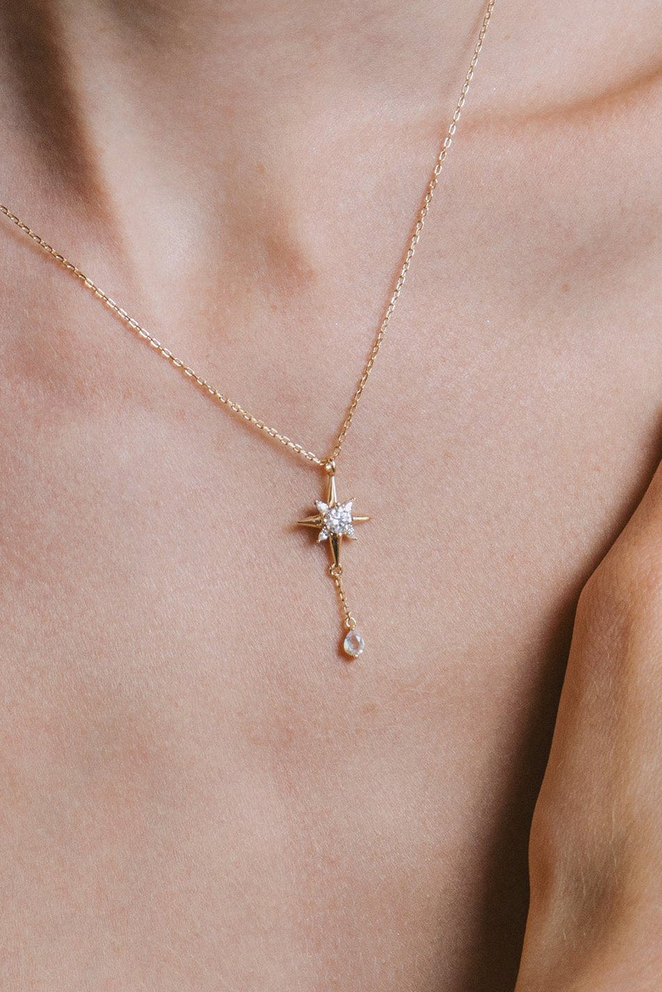 Gold north star necklace with a dangle moonstone.