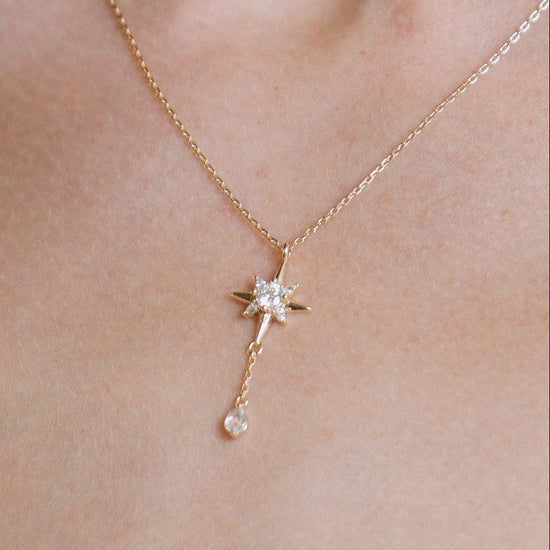 Gold north star necklace with a dangle moonstone.