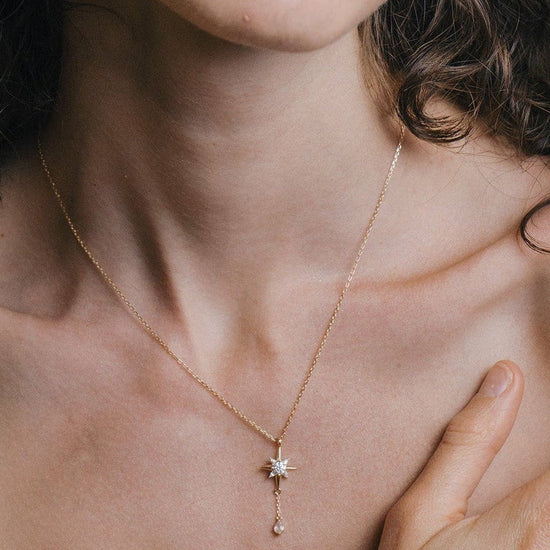 Gold north star necklace with a dangle moonstone.