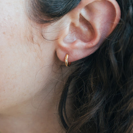 Gold small hoop earrings with engraved star details and moissanites accents