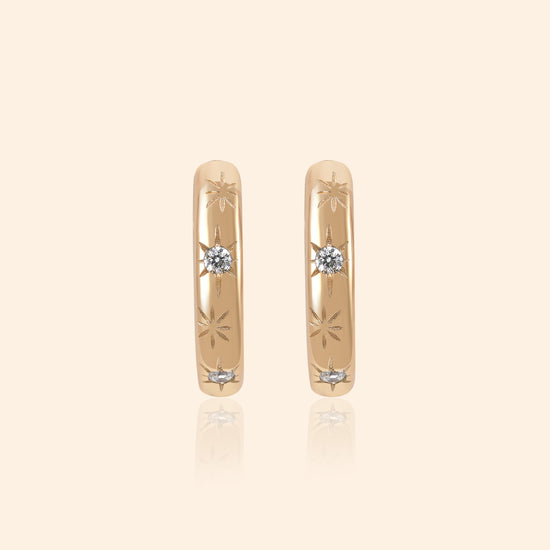 Gold small hoop earrings with engraved star details and moissanites accents