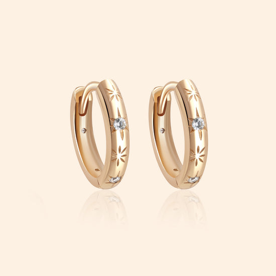 Gold small hoop earrings with engraved star details and moissanites accents