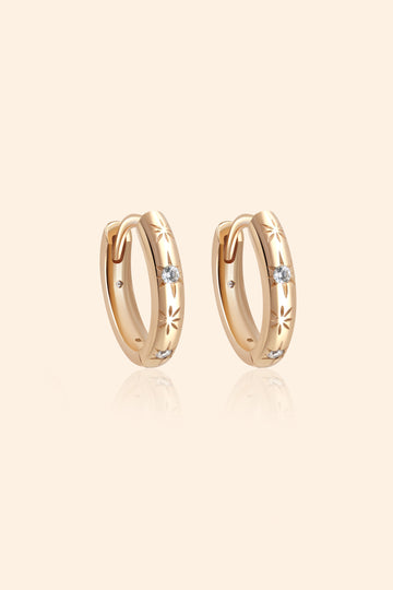 Gold small hoop earrings with engraved star details and moissanites accents