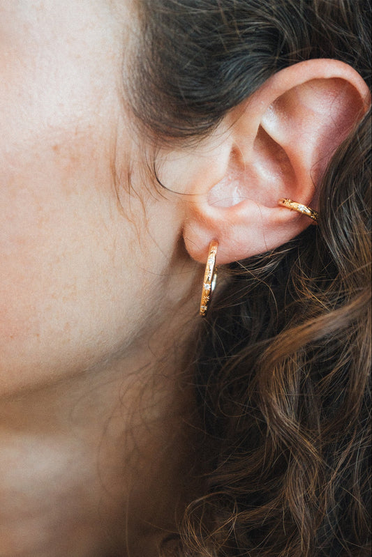 Gold medium hoop earrings with engraved star details and moissanite accents