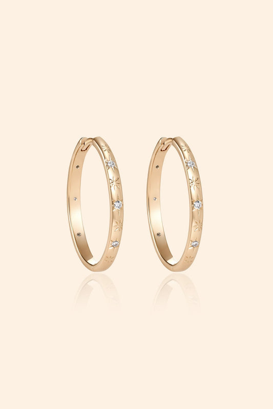 Gold medium hoop earrings with engraved star details and moissanite accents