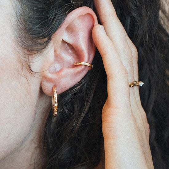 Gold celestial ear cuff with engraved starburst details and moissanite accents