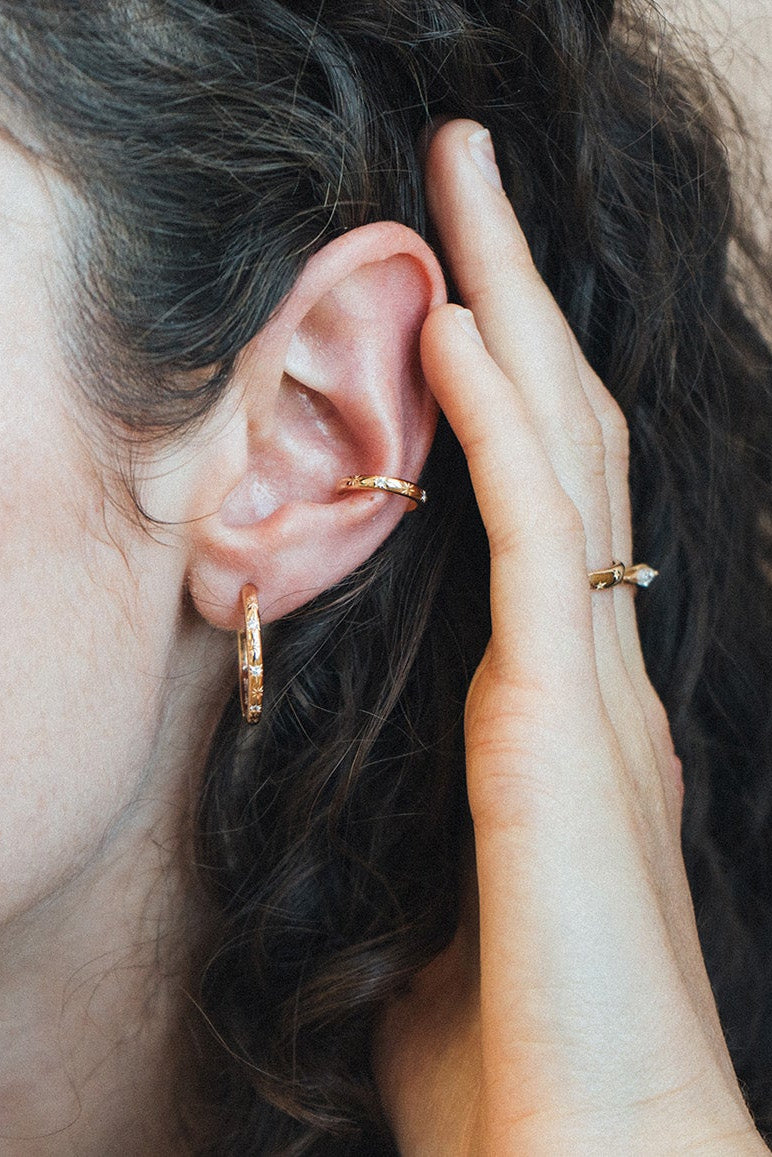 Gold celestial ear cuff with engraved starburst details and moissanite accents