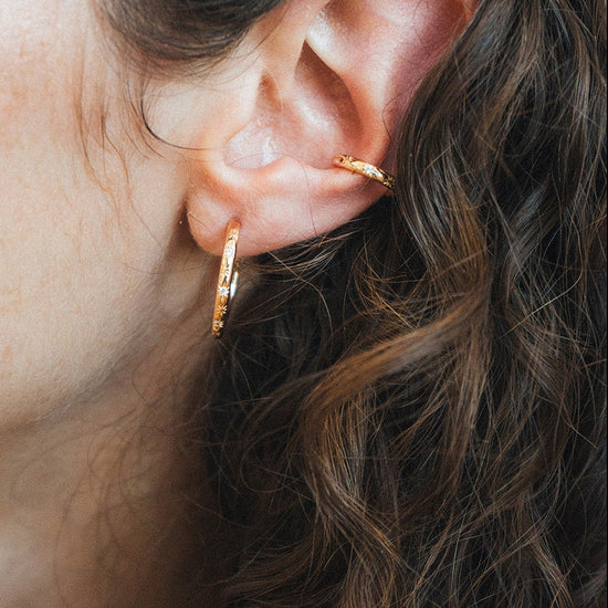 Gold celestial ear cuff with engraved starburst details and moissanite accents