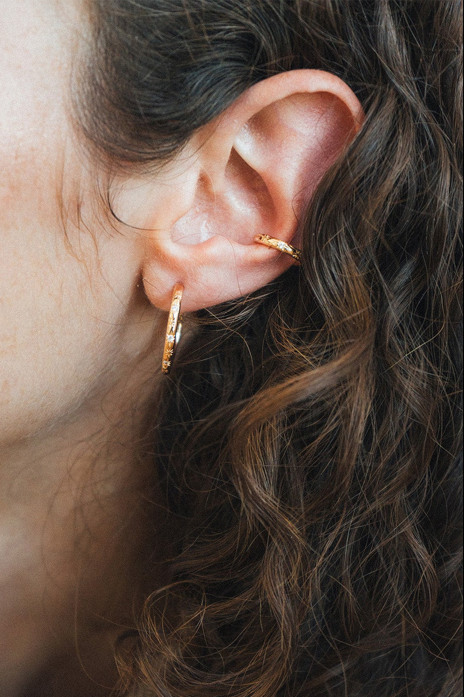Gold celestial ear cuff with engraved starburst details and moissanite accents