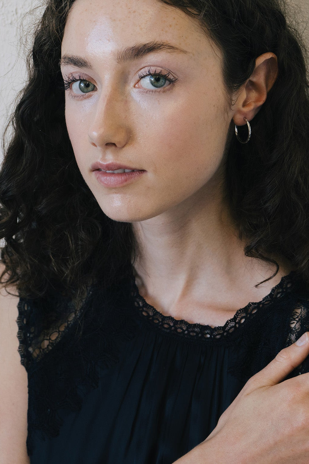 Silver medium hoop earrings with engraved star details and moissanites accents.