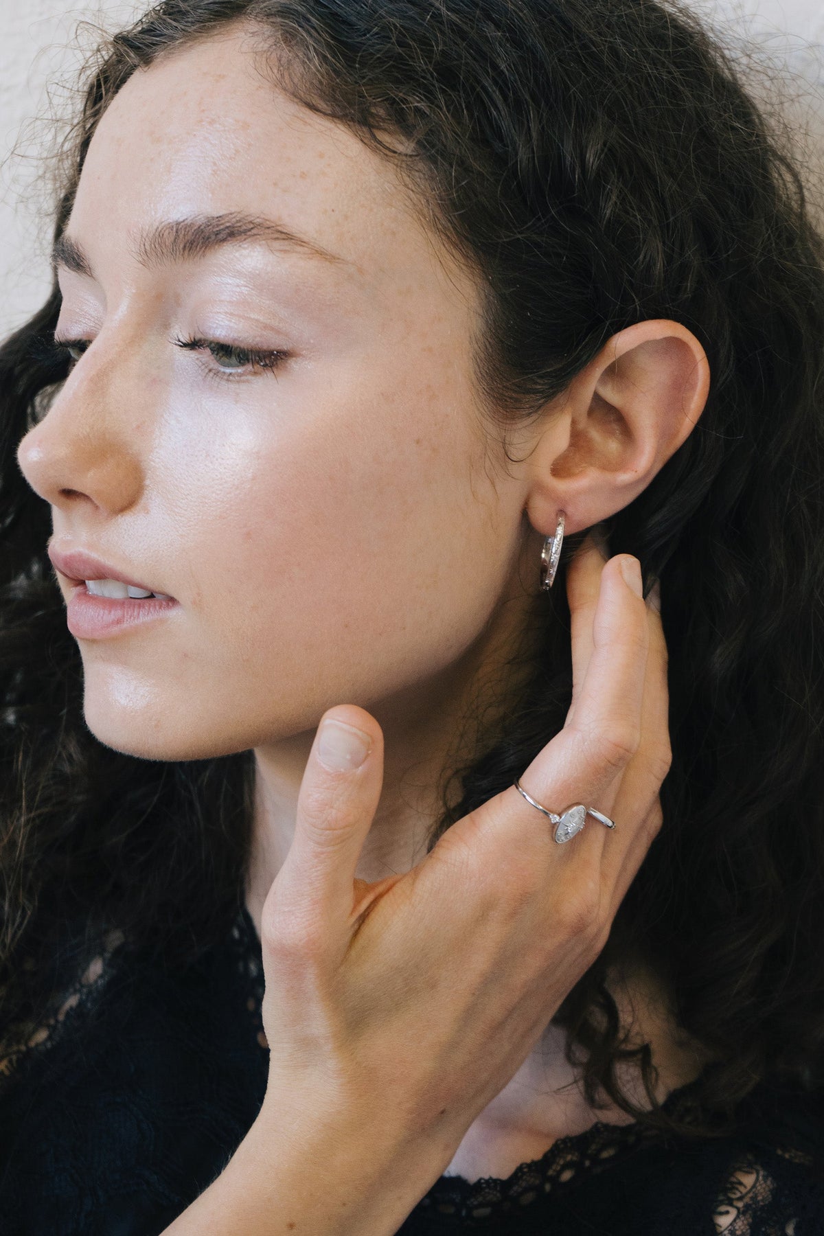 Silver medium hoop earrings with engraved star details and moissanites accents.