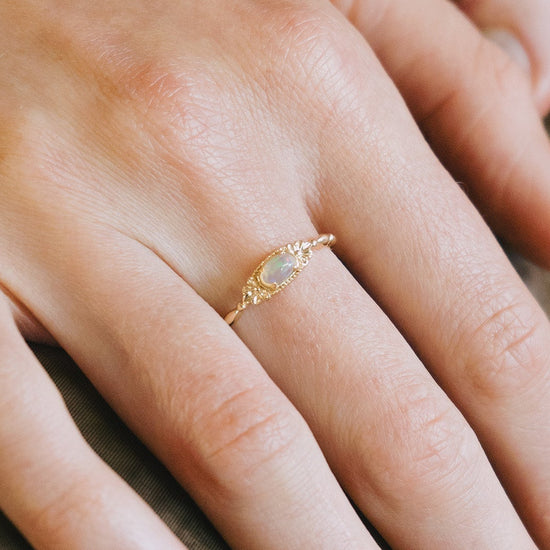 Gold vintage-inspired floral ring with oval opal center stone