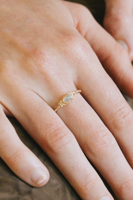Gold vintage-inspired floral ring with oval opal center stone