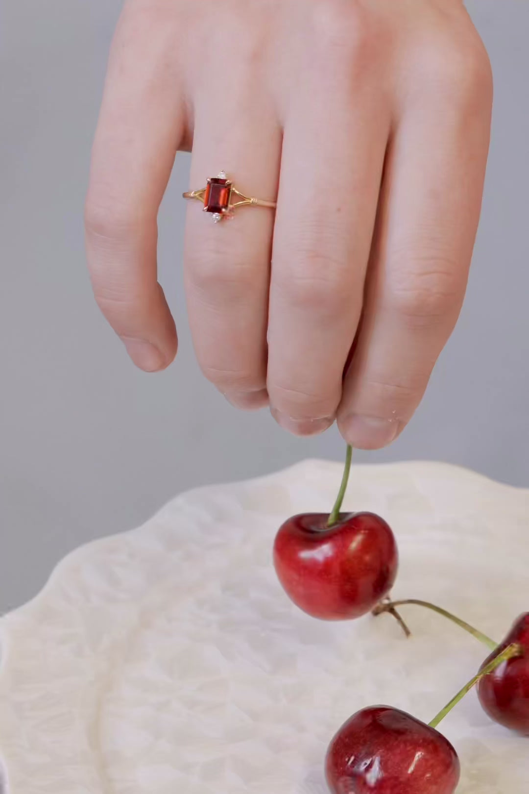 Dainty gold ring with emerald-cut garnet and sparkling moissanite accents