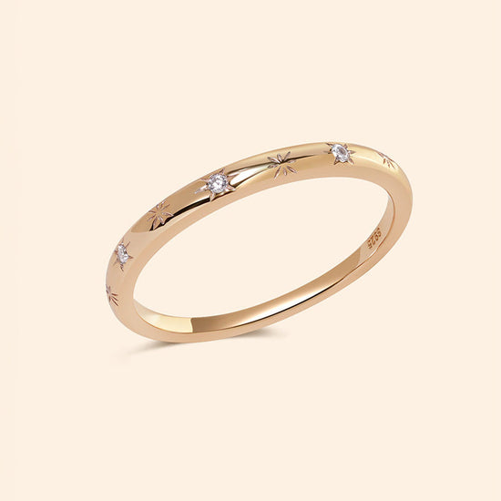 Close-up of a 14K gold plated ring with starburst engravings, celestial jewelry by Lirae.